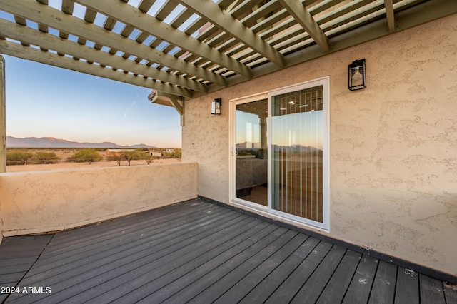 deck at dusk with a pergola and a mountain view