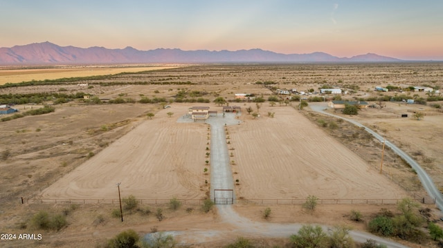 aerial view at dusk featuring a mountain view and a rural view