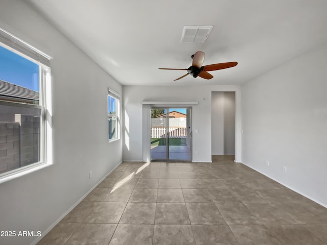 empty room with ceiling fan and light tile patterned floors