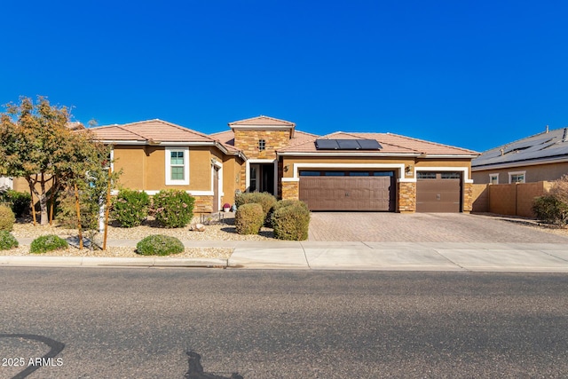 view of front of property featuring a garage and solar panels