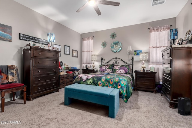 carpeted bedroom with ceiling fan and multiple windows