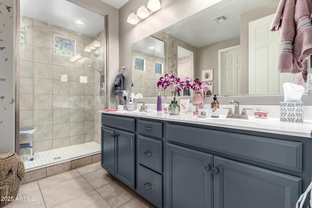 bathroom with tiled shower, tile patterned flooring, and vanity