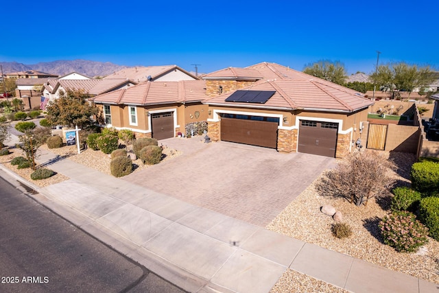 view of front of property featuring a mountain view and solar panels