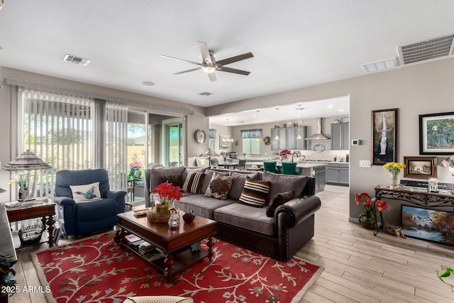 living room featuring light hardwood / wood-style floors and ceiling fan