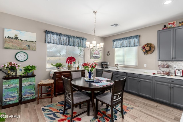 dining room featuring light hardwood / wood-style flooring and a notable chandelier