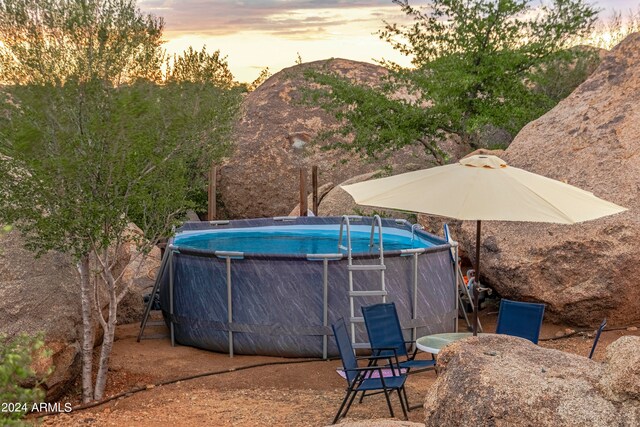 pool at dusk featuring a mountain view