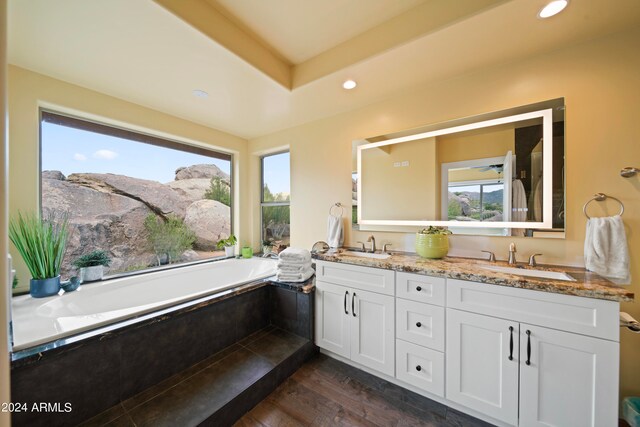 bathroom featuring hardwood / wood-style flooring, vanity, a mountain view, and tiled bath