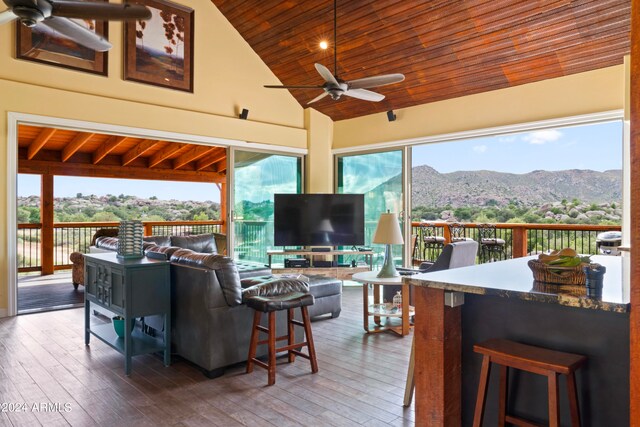 interior space with ceiling fan, lofted ceiling, a wood stove, and wooden ceiling