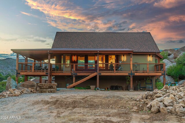 back house at dusk featuring a deck with mountain view