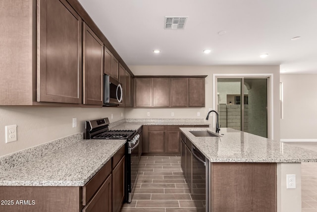 15599 S 180th Ln, Goodyear, AZ 85338 - kitchen featuring stainless steel appliances, a sink, a kitchen island with sink, recessed lighting, and light stone counters