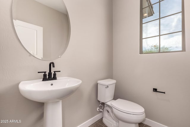 15599 S 180th Ln, Goodyear, AZ 85338 - half bathroom featuring baseboards, toilet, and plenty of natural light