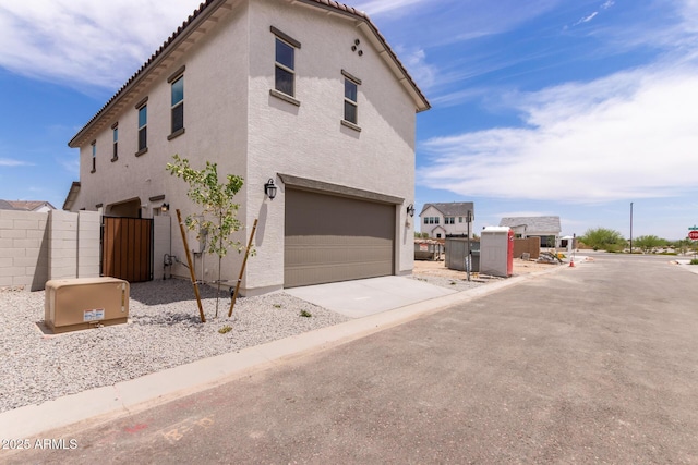 15599 S 180th Ln, Goodyear, AZ 85338 - view of home's exterior with an attached garage, stucco siding, driveway, and a tile roof