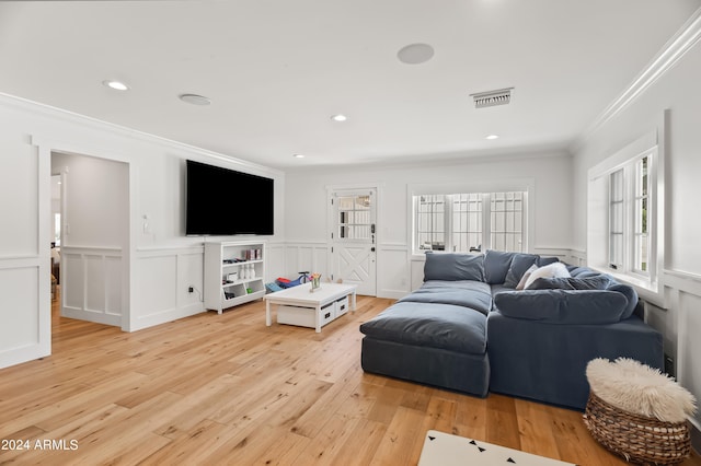 living room with light hardwood / wood-style flooring and crown molding