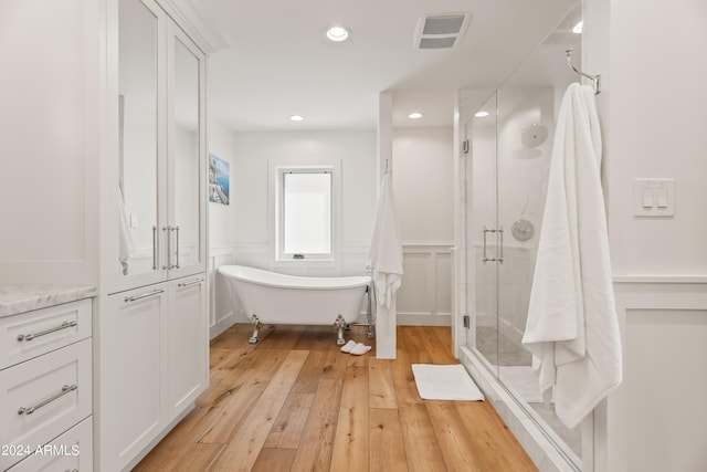 bathroom featuring plus walk in shower, hardwood / wood-style flooring, and vanity