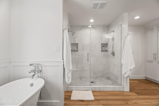 bathroom with plus walk in shower and hardwood / wood-style flooring