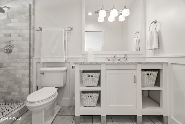 bathroom featuring a shower with door, toilet, and vanity