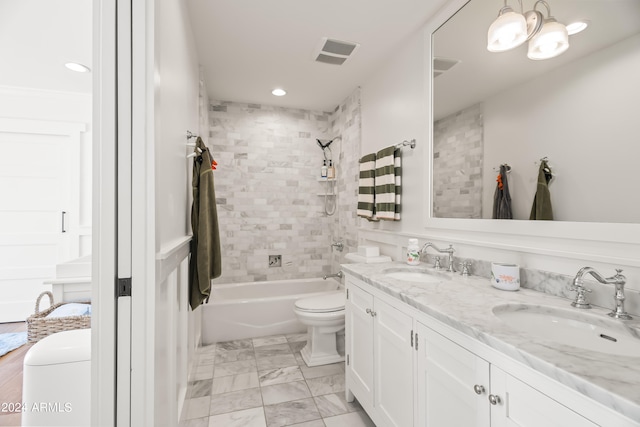 full bathroom with a notable chandelier, vanity, tiled shower / bath, and toilet