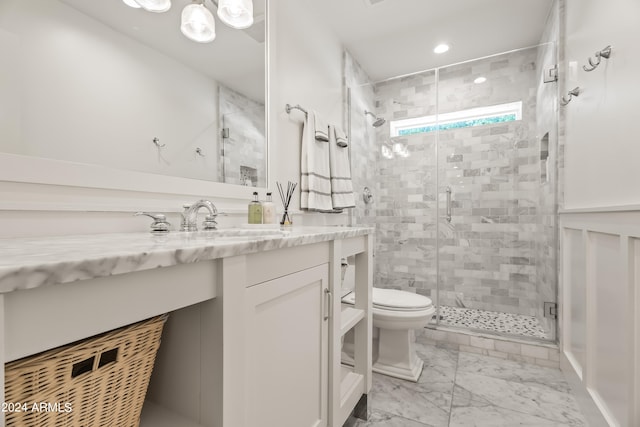 bathroom with a shower with door, vanity, and toilet