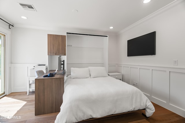 bedroom with ornamental molding and light hardwood / wood-style flooring