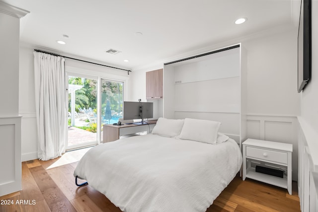 bedroom with access to outside, ornamental molding, and light hardwood / wood-style floors