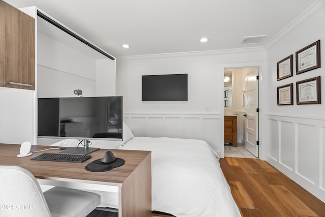 bedroom with ornamental molding, ensuite bath, and light hardwood / wood-style floors