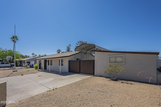 4025 E Surrey Ave, Phoenix, AZ 85032 - view of front facade with concrete driveway, a detached carport, and stucco siding