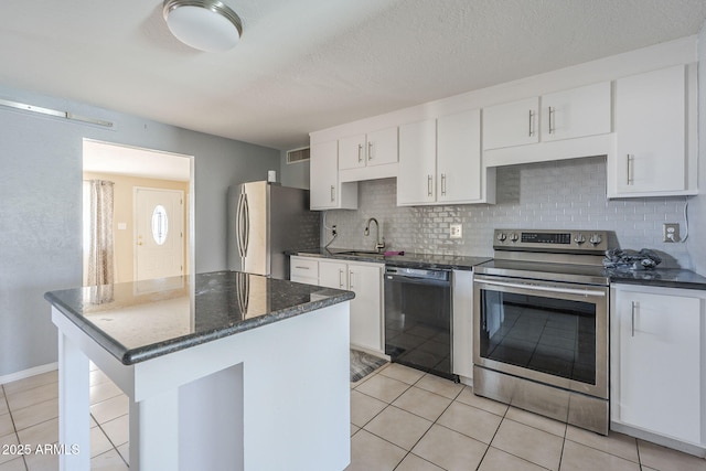 4025 E Surrey Ave, Phoenix, AZ 85032 - kitchen featuring appliances with stainless steel finishes, light tile patterned flooring, a sink, white cabinetry, and backsplash