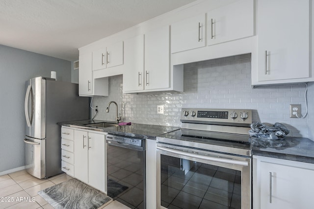 4025 E Surrey Ave, Phoenix, AZ 85032 - kitchen with appliances with stainless steel finishes, a sink, white cabinets, backsplash, and light tile patterned floors