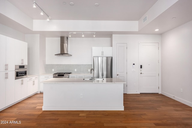 kitchen with a center island with sink, white cabinetry, wood-type flooring, wall chimney exhaust hood, and stainless steel appliances