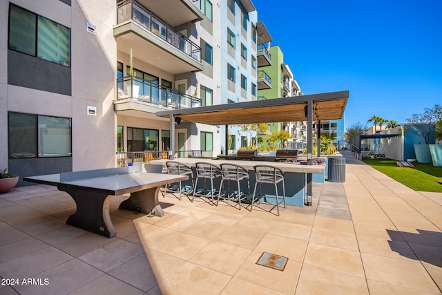 view of patio featuring an outdoor bar and a balcony