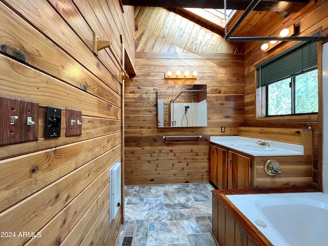 bathroom with wood ceiling, a bath, vanity, lofted ceiling with skylight, and wooden walls