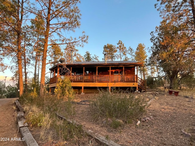 back house at dusk featuring a deck