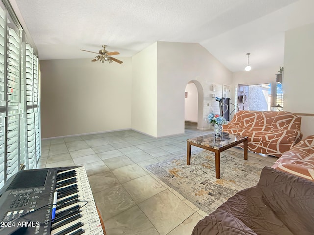 tiled living room featuring ceiling fan, a textured ceiling, and vaulted ceiling