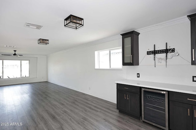 bar featuring wine cooler, ornamental molding, and plenty of natural light