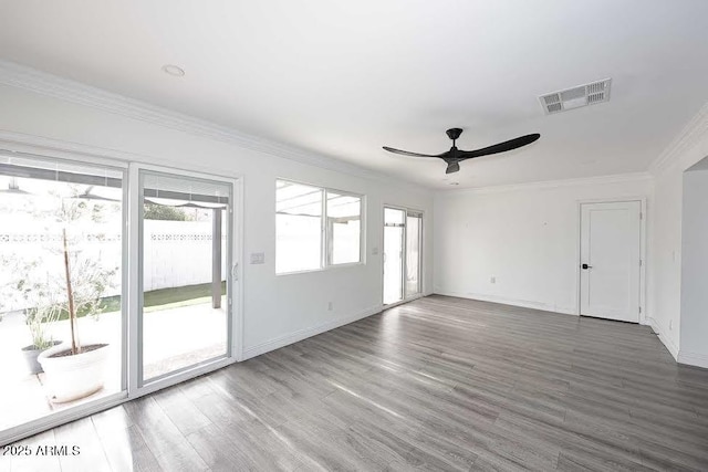 spare room featuring wood-type flooring, ornamental molding, and a healthy amount of sunlight