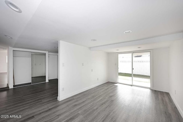 spare room featuring floor to ceiling windows and dark hardwood / wood-style flooring