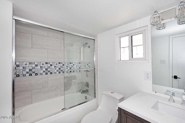 full bathroom featuring vanity, shower / bath combination with glass door, and toilet