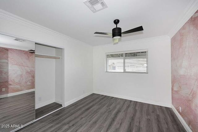 unfurnished bedroom featuring crown molding, ceiling fan, dark wood-type flooring, and a closet