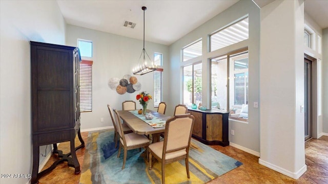 dining area with a wealth of natural light, tile patterned floors, and a chandelier