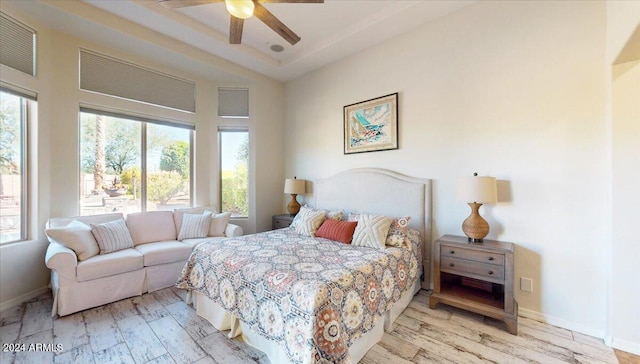 bedroom featuring light hardwood / wood-style flooring, multiple windows, and ceiling fan