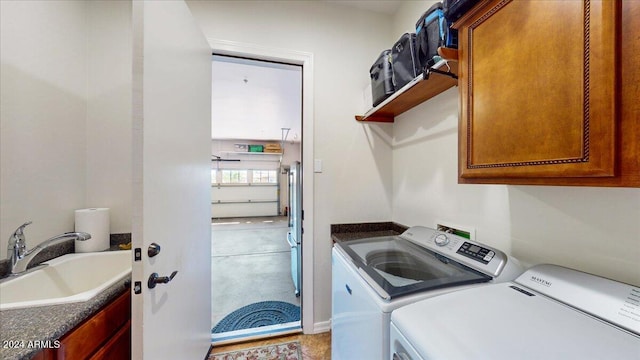 washroom featuring sink, independent washer and dryer, and cabinets