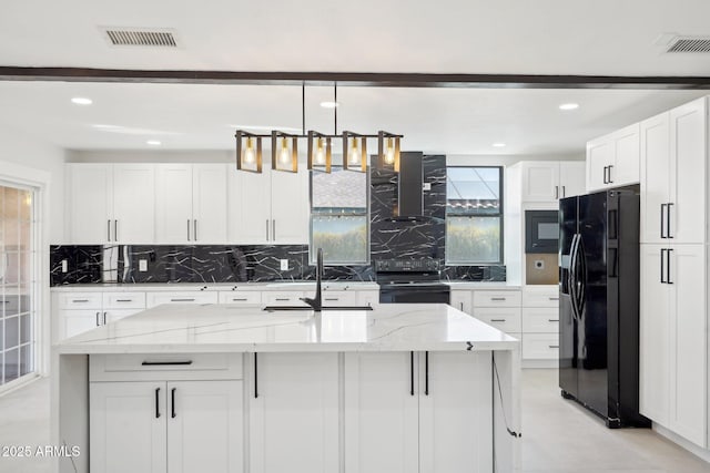 kitchen with visible vents, white cabinets, light stone counters, black appliances, and a sink