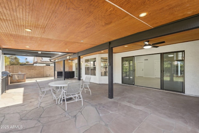 view of patio featuring outdoor dining space, fence, and a ceiling fan