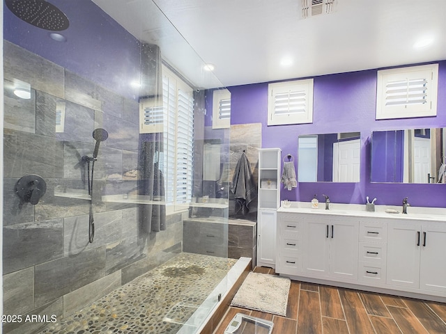 bathroom featuring tiled shower and vanity