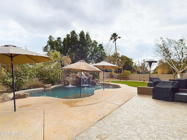 view of pool featuring pool water feature, a grill, and a patio area