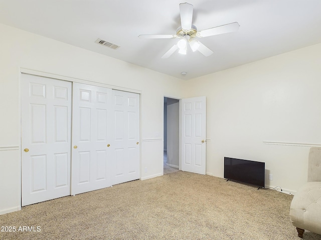 unfurnished bedroom with ceiling fan, carpet floors, and a closet