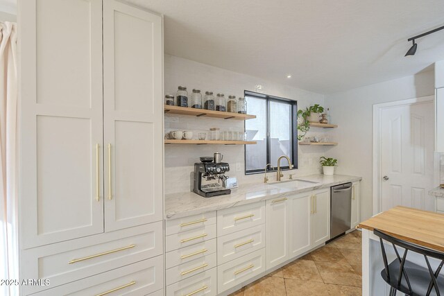 bar featuring sink, white cabinetry, dishwasher, and light stone counters