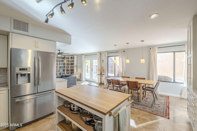 kitchen with hanging light fixtures, french doors, stainless steel refrigerator with ice dispenser, white cabinetry, and ceiling fan