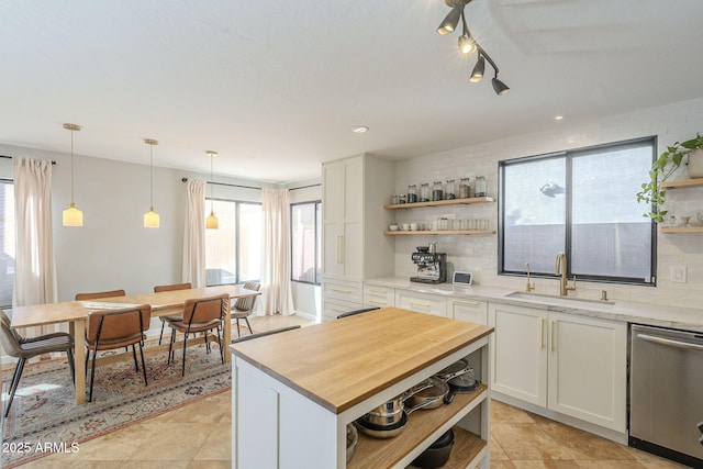 kitchen with dishwasher, hanging light fixtures, decorative backsplash, white cabinets, and sink