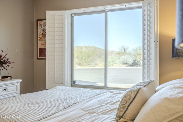 bedroom featuring multiple windows and a mountain view